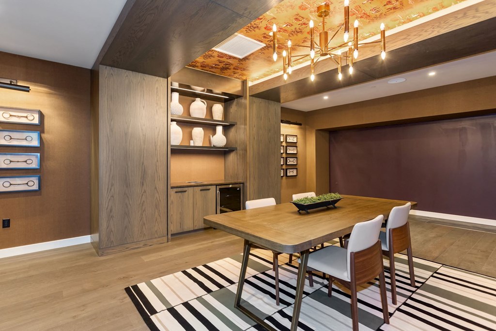 a dining room with a wooden dining table and white chairs on top of a black and white at Vyne One Loudoun, Virginia