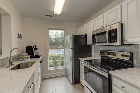 a kitchen with stainless steel appliances and white cabinets