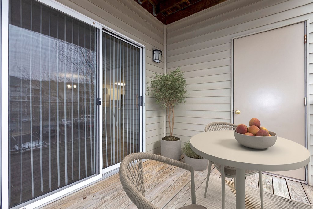 a patio with a table and chairs and a bowl of fruit