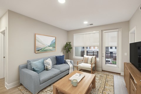 A living room with a grey couch, a wooden coffee table, and a painting on the wall.