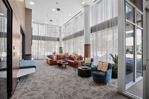 A modern living room with a grey carpet and a variety of seating options.