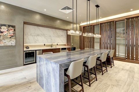 a large kitchen with a marble counter top and a long table