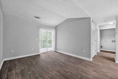 A room with wooden flooring and white walls.