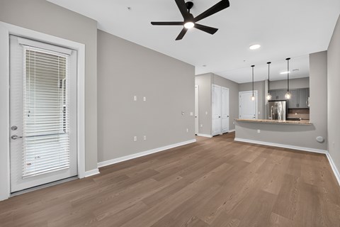 A room with a ceiling fan and wooden flooring.