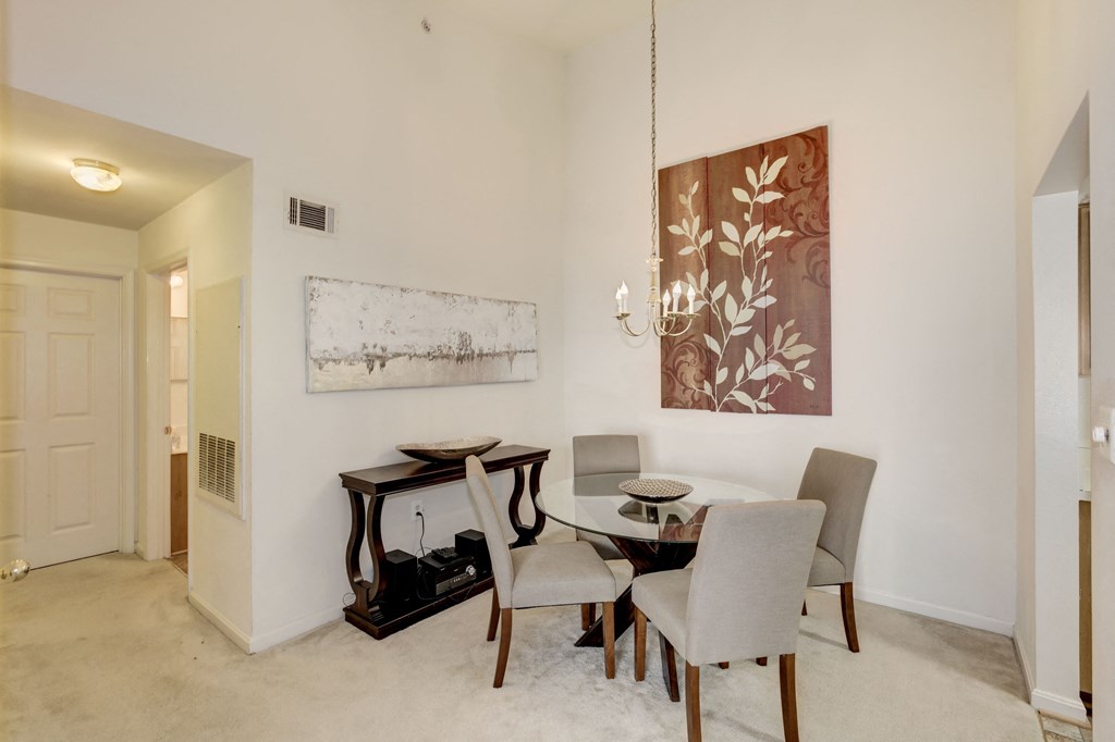 a dining room with a table and chairs and a painting on the wall