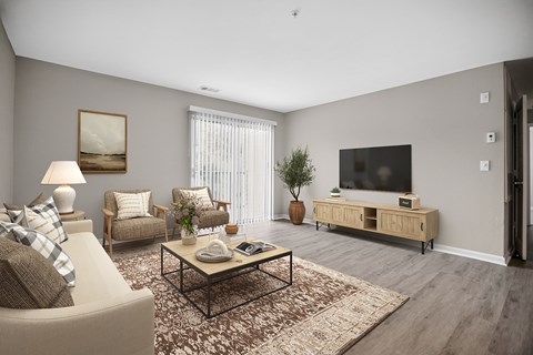 A living room with a sofa, armchairs, a coffee table, and a television.
