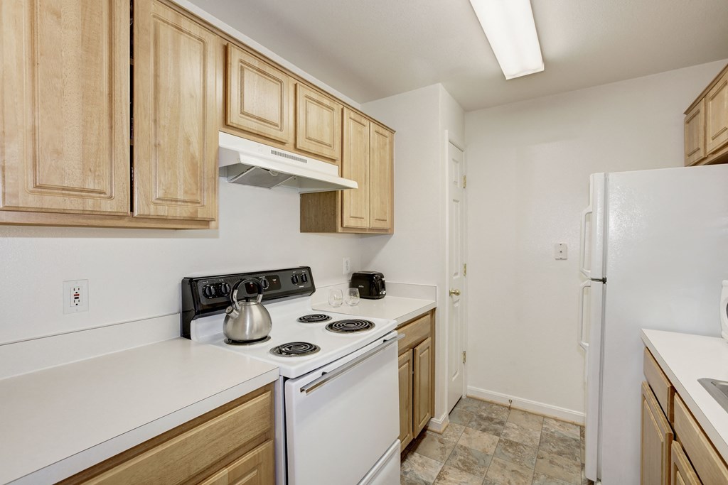 a kitchen with white appliances and wooden cabinets and a white refrigerator