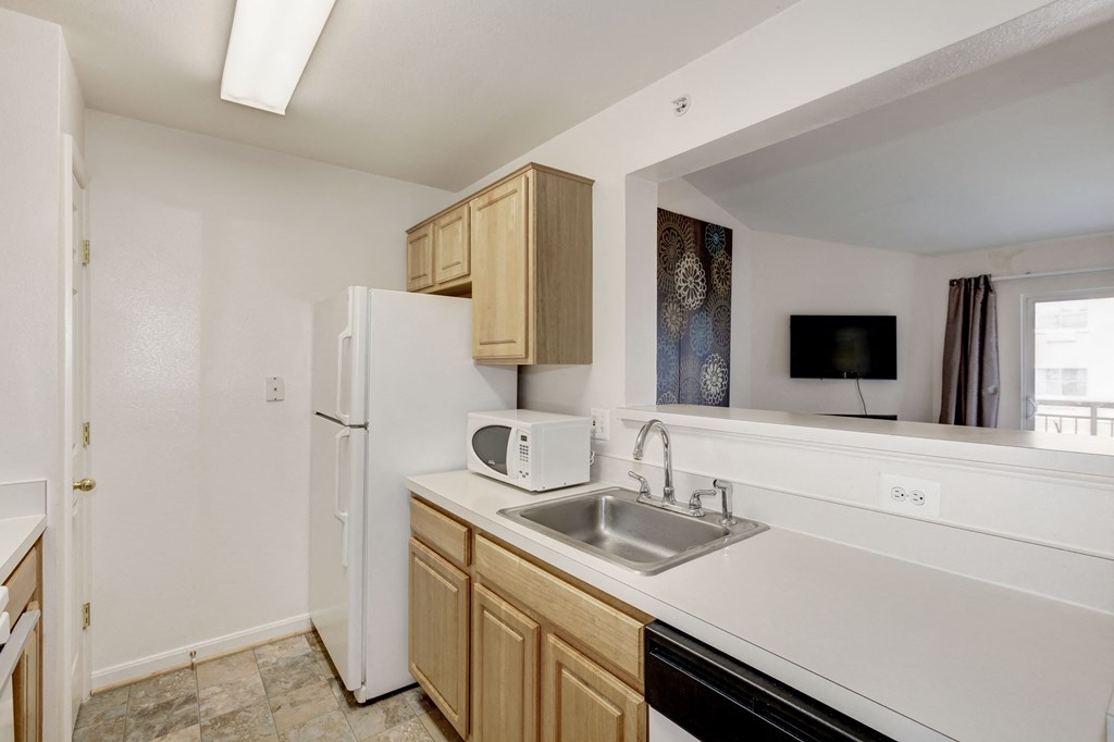 an empty kitchen with a sink and a refrigerator