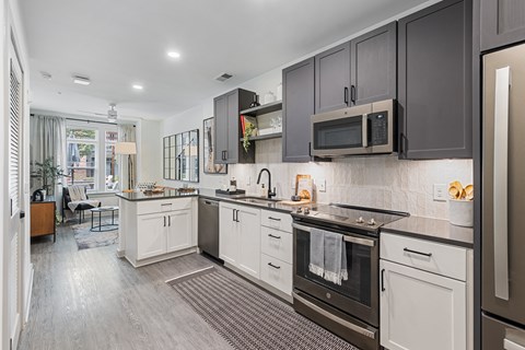A modern kitchen with dark brown cabinets and stainless steel appliances.