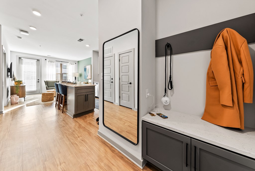 A modern kitchen with a wooden floor and a large mirror on the wall
