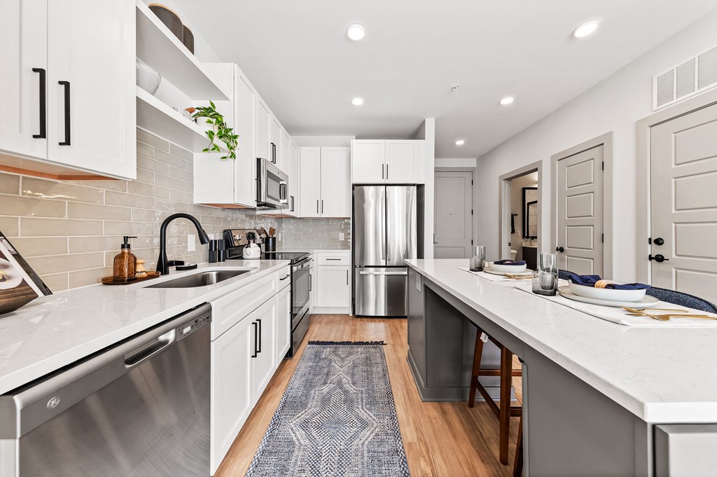 A modern kitchen with white cabinets and a stainless steel dishwasher.
