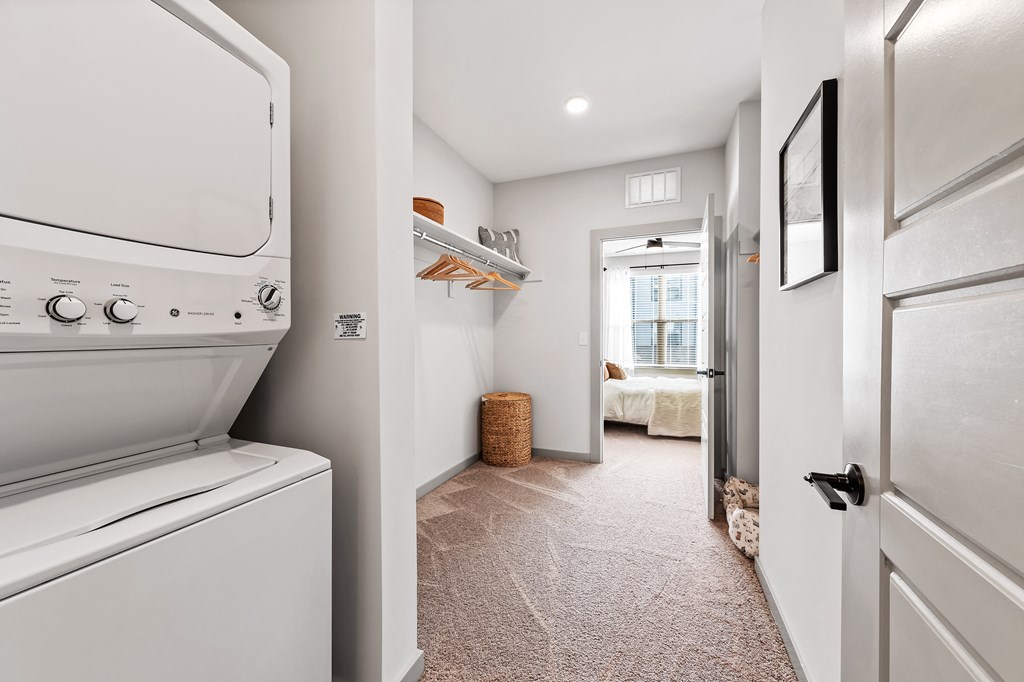 A white washing machine is in a narrow hallway