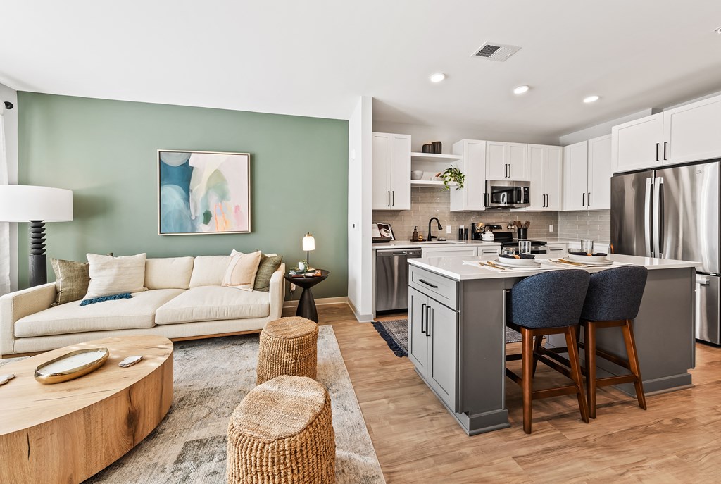 A modern kitchen with a breakfast bar and a living room area