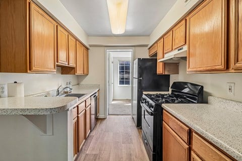 A kitchen with wooden cabinets and a black stove top oven.