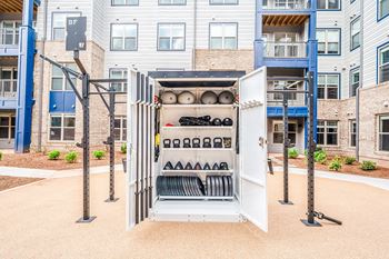 A white utility box is open in the middle of a courtyard.