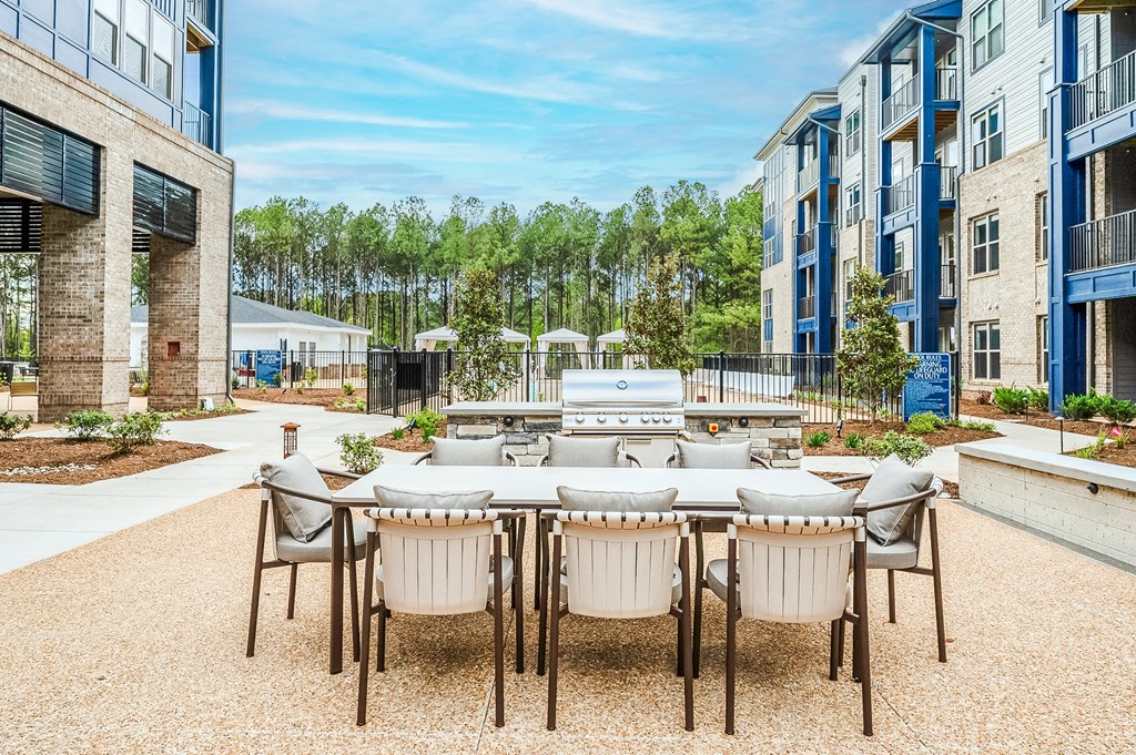 an outdoor patio area with a table and chairs and a grill at Preston Ridge, Cary, 27513