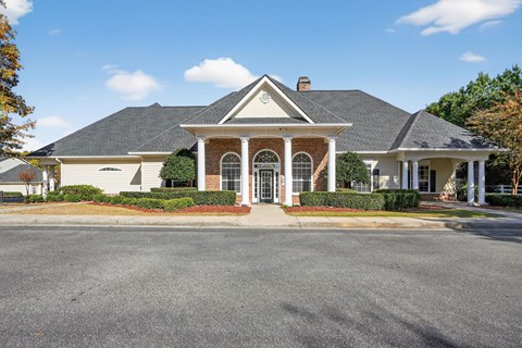 A house with a brick chimney and a porch with columns.