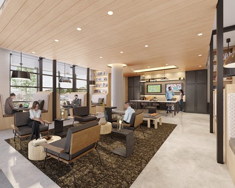 A modern office space with people working at desks and a large screen on the wall.