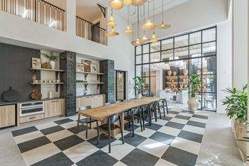 a dining room with a long wooden table and chairs in front of a large window at La Unión, Tampa, FL