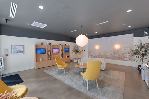 A modern living room with a yellow chair and a grey rug.