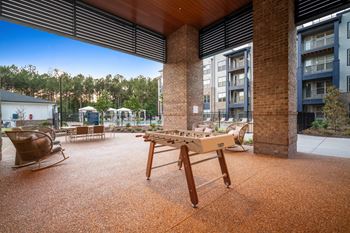 A wooden table is in the middle of a courtyard.