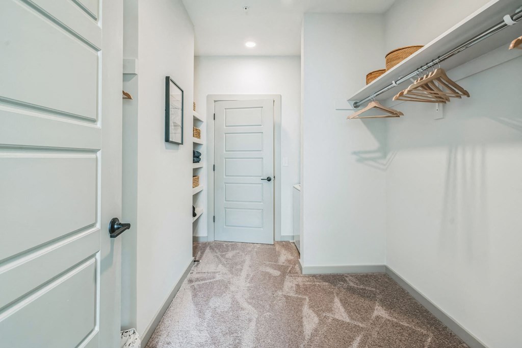 a hallway with a closet and a white door at Preston Ridge, Cary, 27513