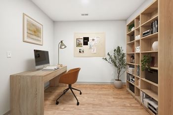 A room with a desk, chair, and bookshelf.