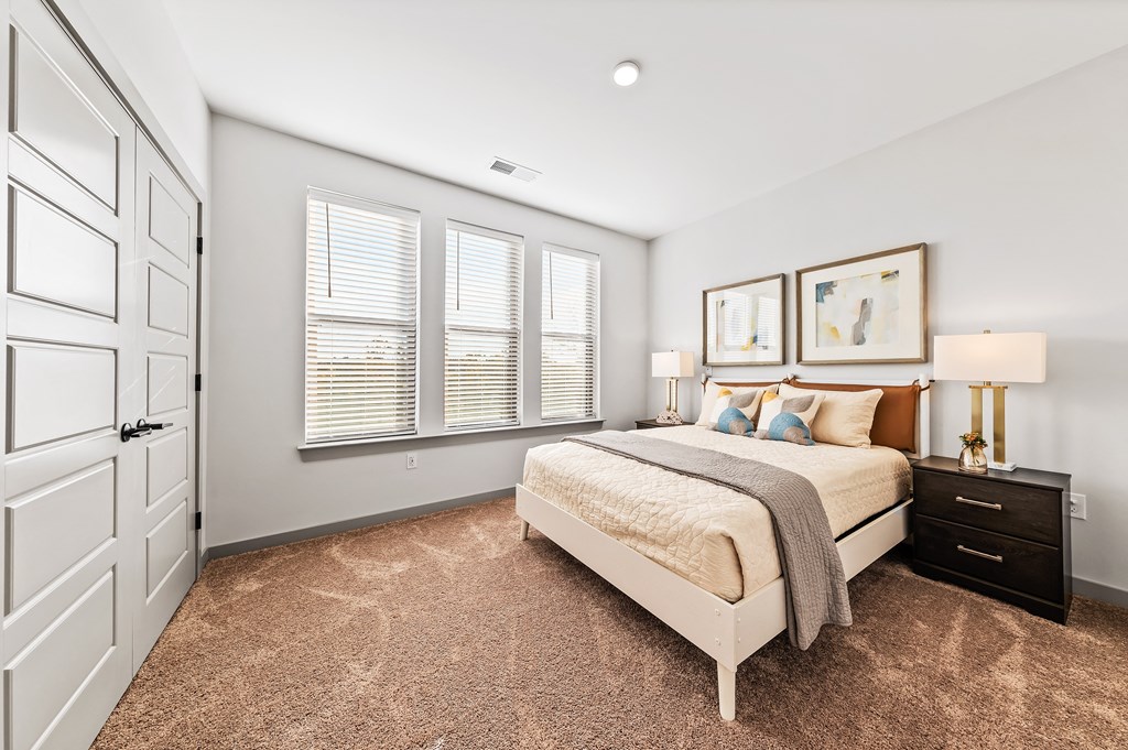 A bedroom with a bed, dresser, and two framed pictures on the wall