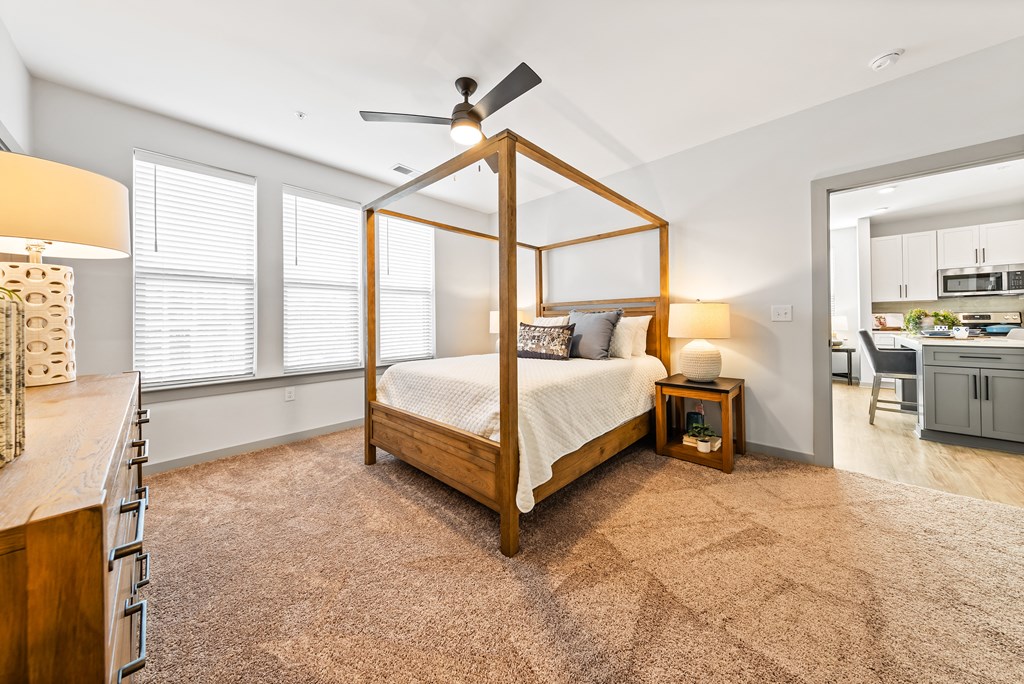 A bedroom with a four poster bed and a ceiling fan