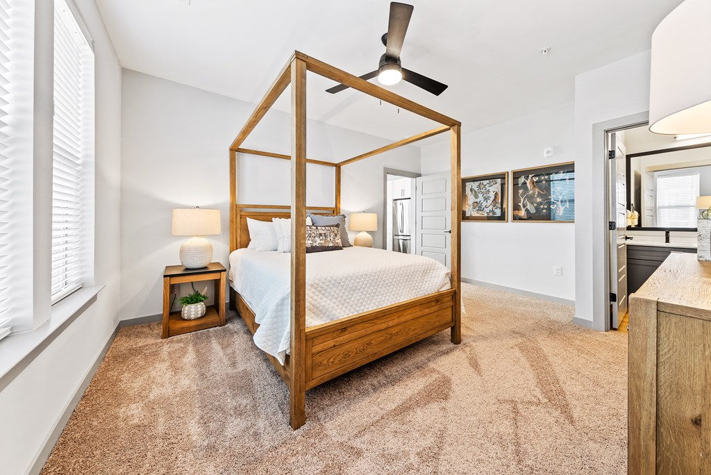 A bedroom with a four poster bed and a carpet