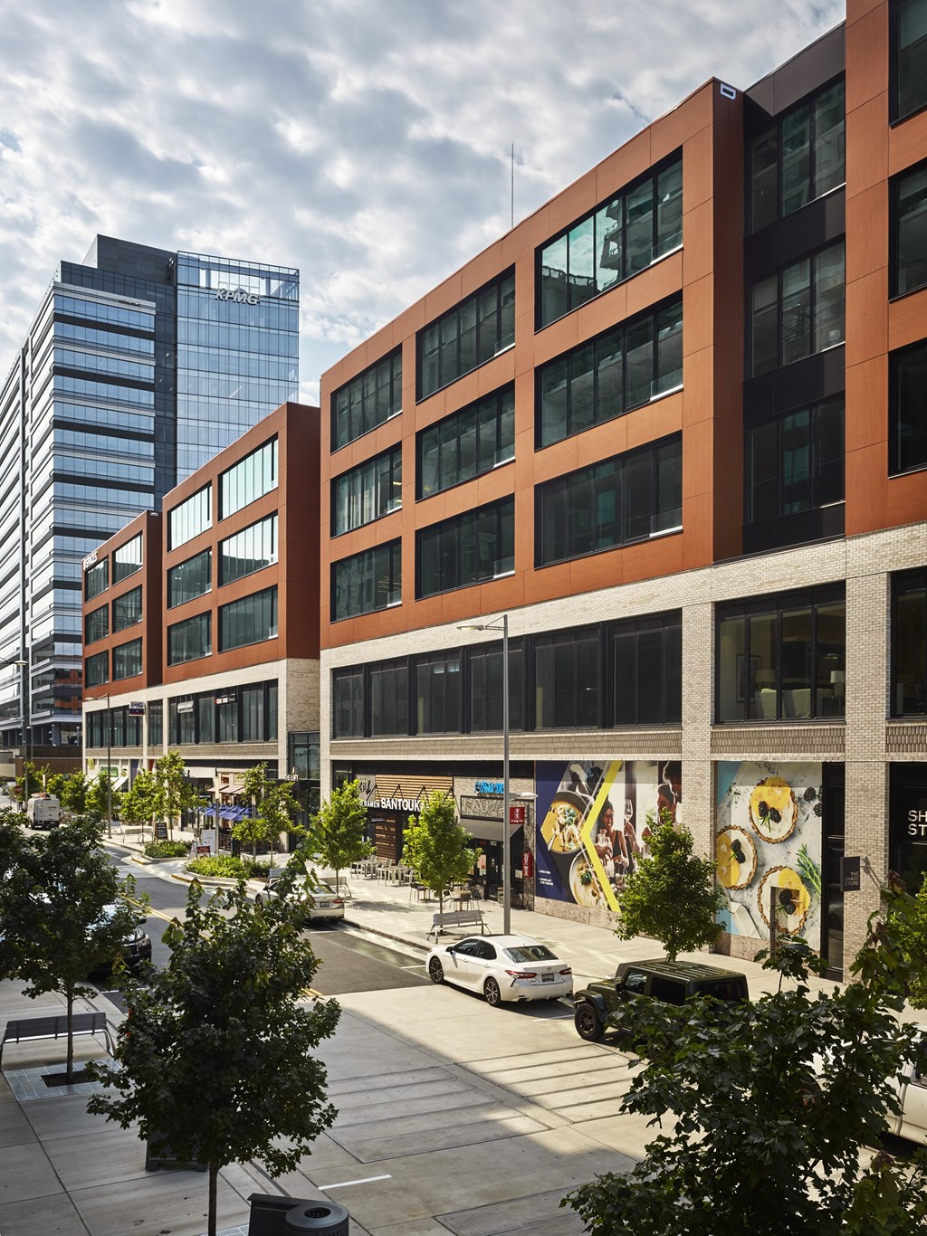 a large brick building with many windows and a street in front of it at The Boro, Tysons, VA
