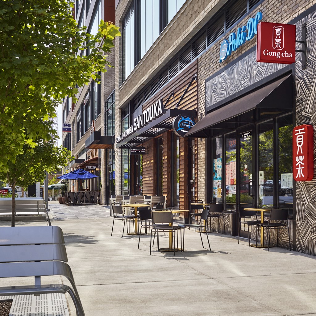 a sidewalk with tables and chairs in front of a restaurant at The Boro, Tysons, VA 22102