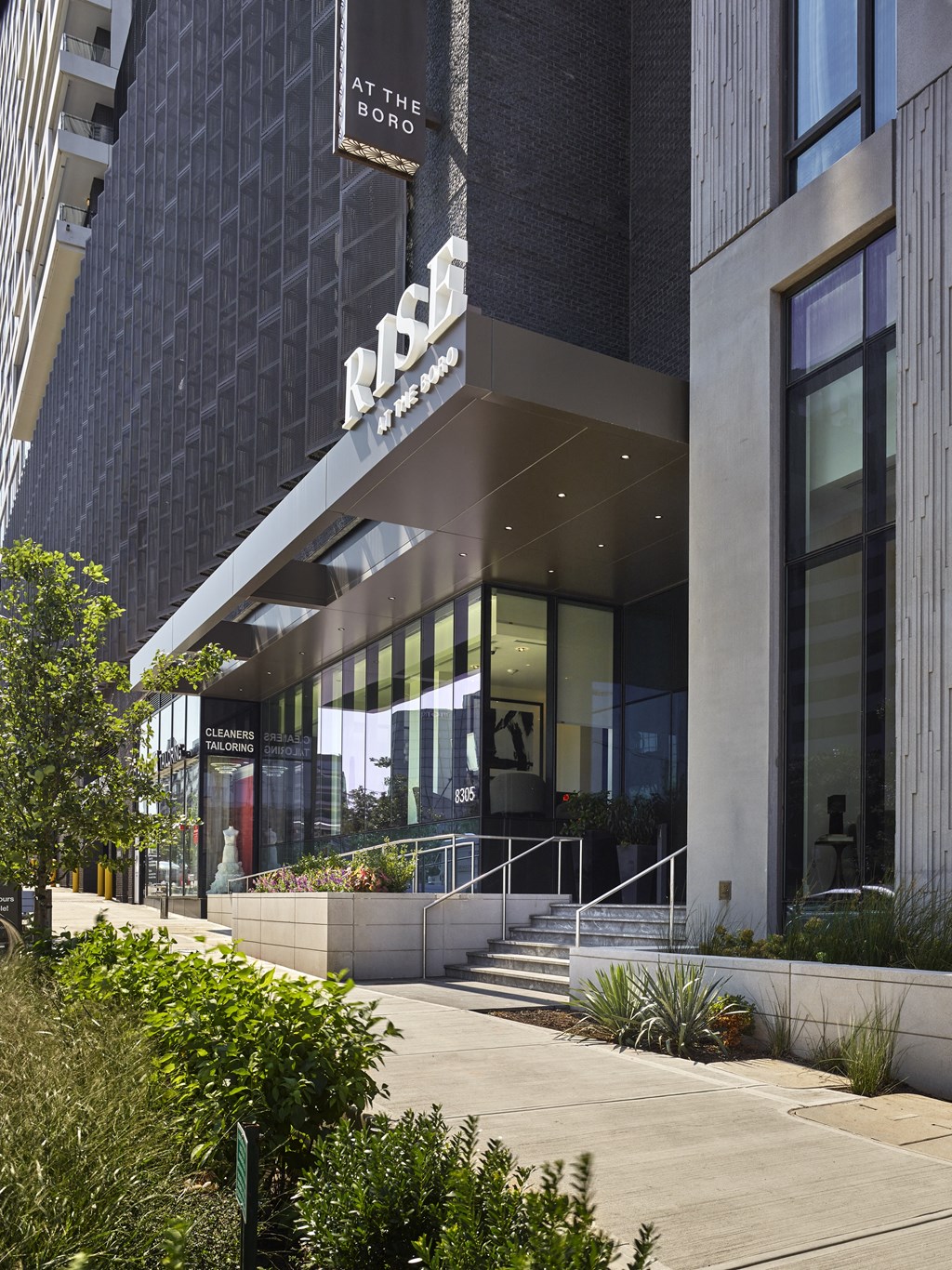 a cityscape with tall buildings and a street in the foreground at The Boro, Tysons, VA
