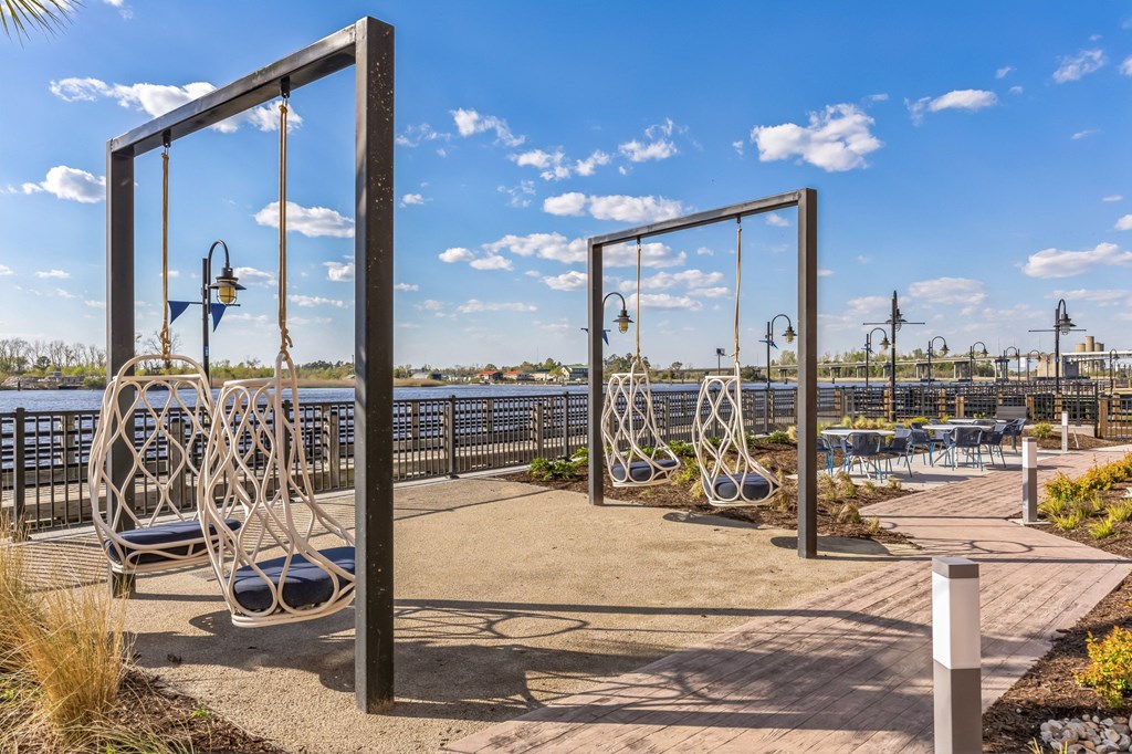 Courtyard with swings and a view of the water at Metropolitan at the Riverwalk, Wilmington, NC