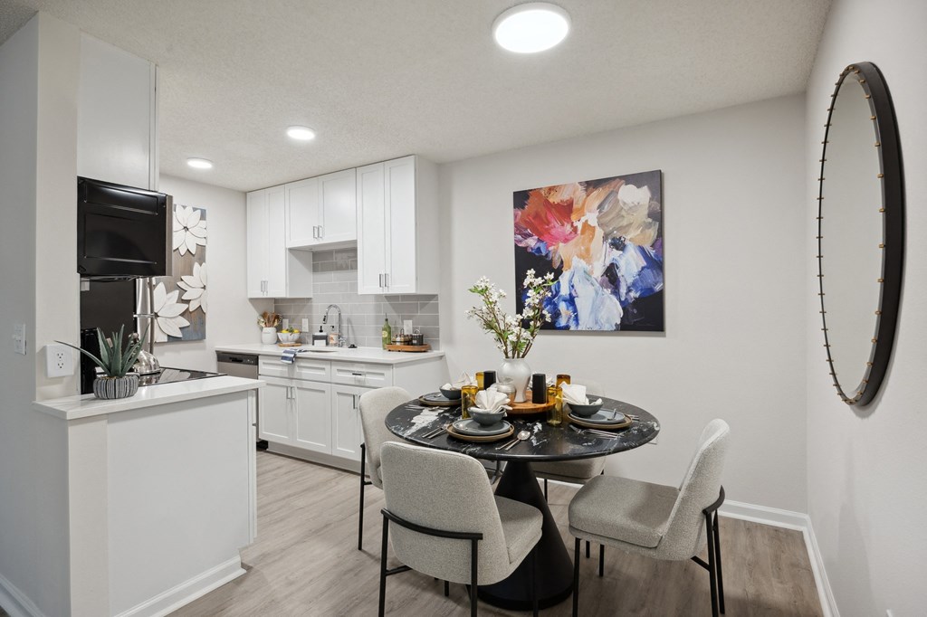 our apartments offer a dining room and kitchen with white cabinets and appliances at St. Andrews Reserve, Wilmington, North Carolina