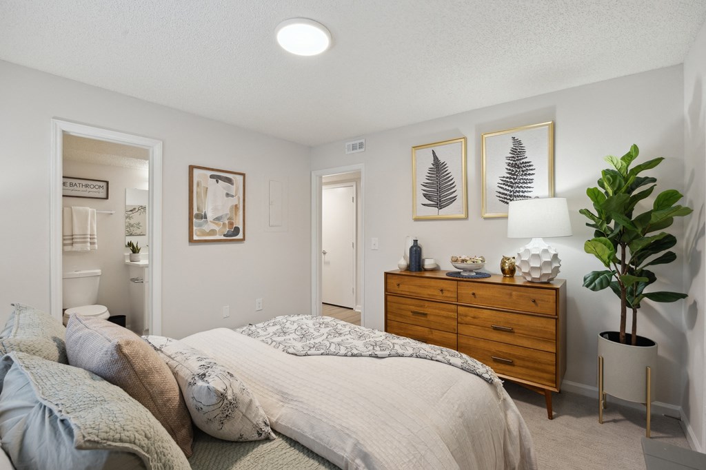 a bedroom with a bed and a dresser and a bathroom at St. Andrews Reserve, Wilmington, NC