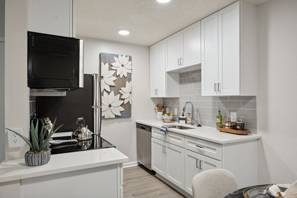 an open kitchen with white cabinets and a sink and a refrigerator at St. Andrews Reserve, Wilmington, NC