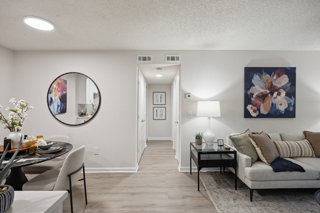 the living room and dining room of an apartment with a couch and a table at St. Andrews Reserve, Wilmington, NC