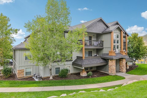 A large house with a grey exterior and a balcony.