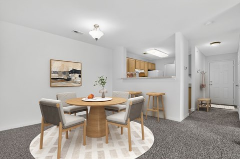 A dining room with a round table and chairs.
