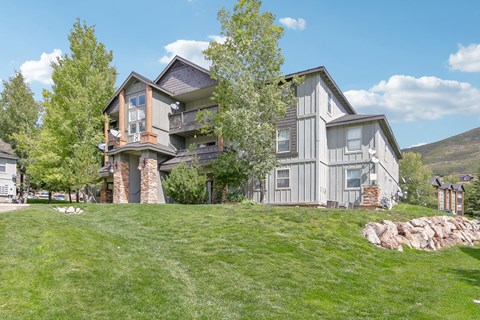 A large house with a grey exterior and a balcony on the second floor.