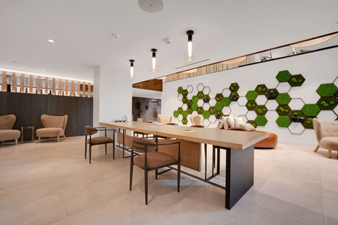 A modern dining room with a long table and chairs.