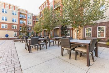 A Patio With Tables and Chairs at The Aster Apartments, Cary