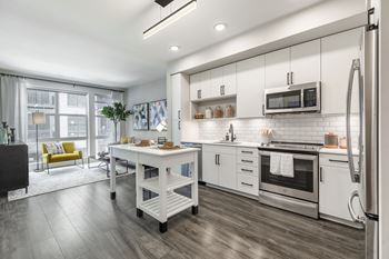 a kitchen with white cabinets and stainless steel appliances at Coda at Bryant Street, Washington, DC