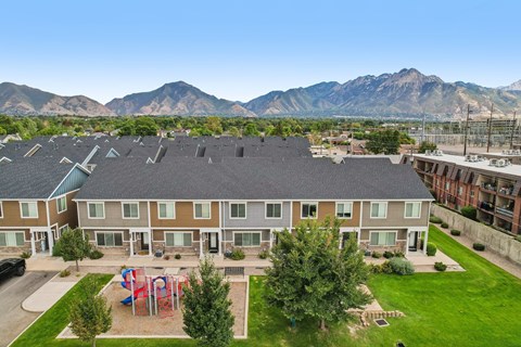 A large apartment complex with a playground in the front yard.