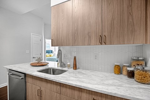 A kitchen with wooden cabinets and a marble countertop.