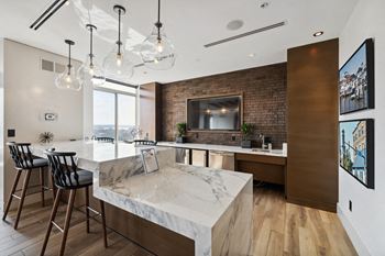 a kitchen with a marble counter top and a bar with stools at Lincoln Old Town, Alexandria, VA 22314