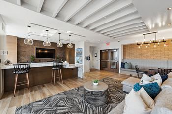 a living room with a couch and a kitchen with a bar at Lincoln Old Town, Alexandria, 22314