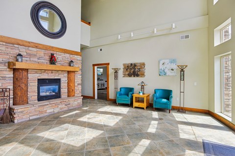 A living room with a fireplace and blue chairs.