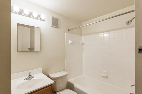 A white bathroom with a sink, toilet, and bathtub.
